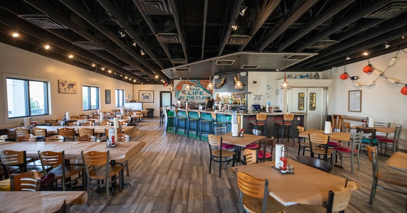 Interior, diner area, tables and chairs, bar behind, wide view
