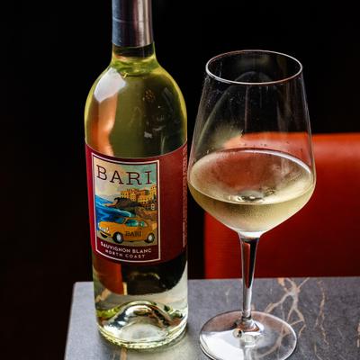 White wine bottle alongside a glass of white wine.