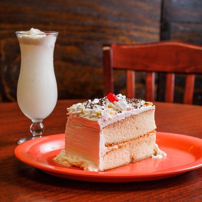 Pina Colada cocktail served on the table with a cake