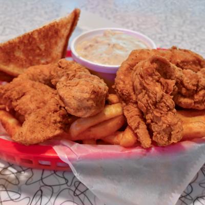 Chicken Strip Meal with sides of fries, toast and a dipping sauce.