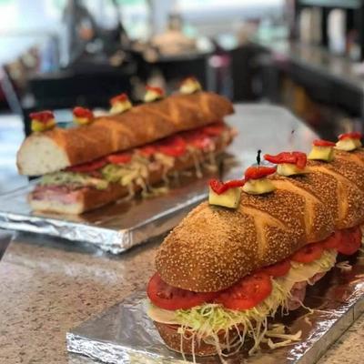 Turkey and ham sandwiches, with cheese, lettuce, tomato, and pickles.