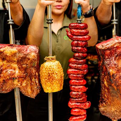 Staff members holding BBQ meat rotisseries  upright