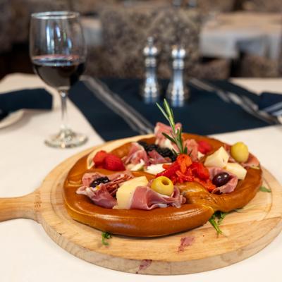 Charcuterie Board featuring a selection of cured meats and cheeses, served inside a jumbo pretzel.