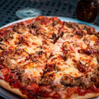 Pizza with cheese, sausage, mushrooms, and onions.