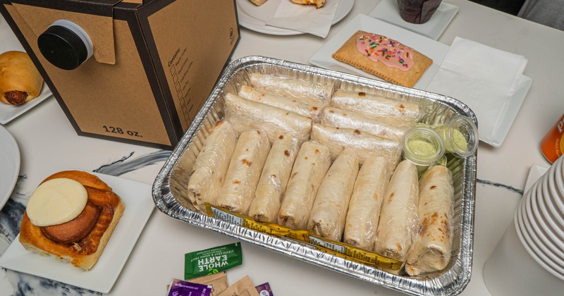 Tray of wrapped burritos with sauces