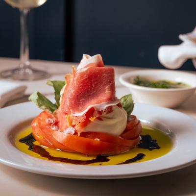 Fresh burrata served with prosciutto, tomatoes, olive oil, and balsamic.