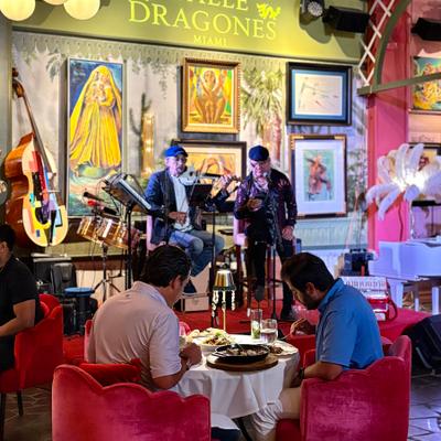 Two man on a table eating while the band called Puño cerrado in playing.
