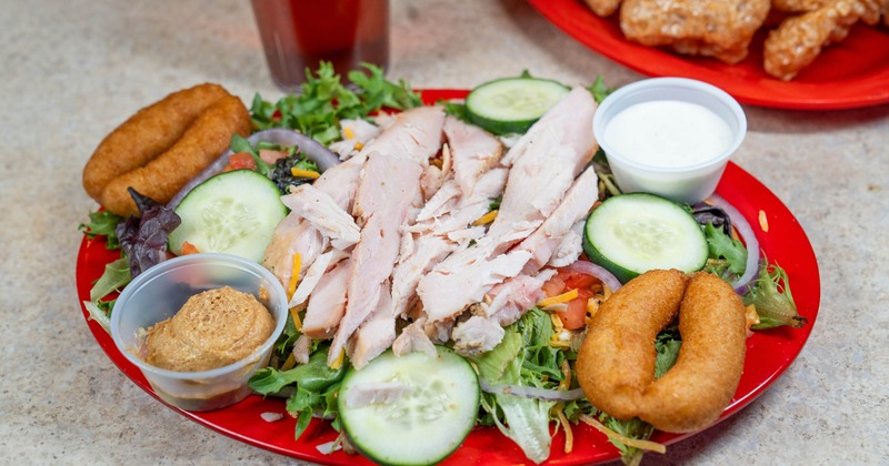 Mix salad topped with turkey and served with two sauces