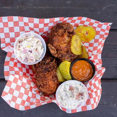Leg Combo served with coleslaw, potato salad, dill pickles and a slice of bread.