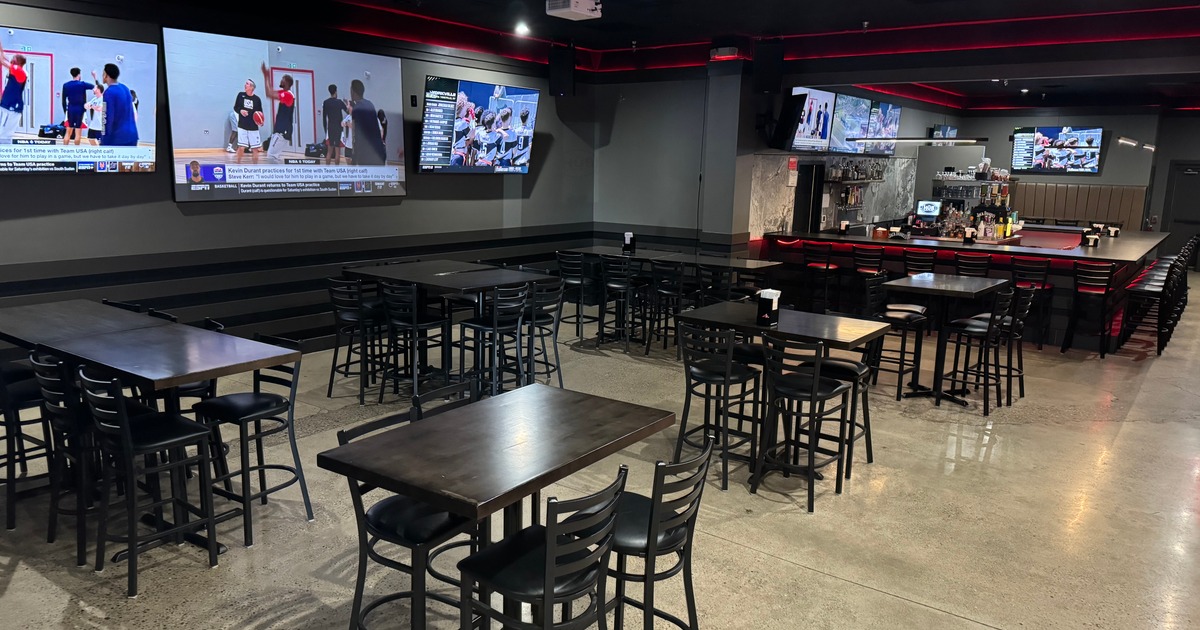 Interior with tables, chairs, countertop seating and multiple TVs