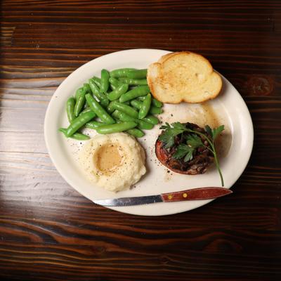 Bacon wrapped filet mignon with mash potatoes , snap peas and toasted french bread.