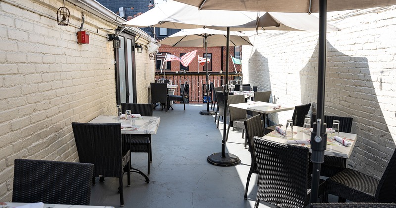 Patio with dining set tables and sunshade umbrellas