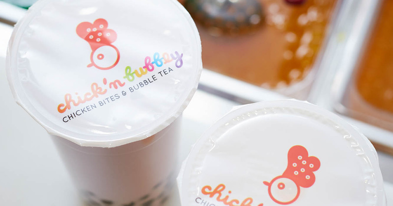 Two cups of bubble tea with the restaurant logo on the covers