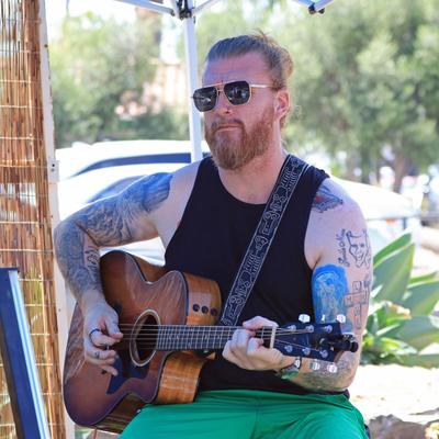 A musician playing an acoustic guitar live.