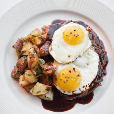 Fried eggs, baked potato and grilled meat