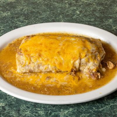 Burrito smothered in cheese and green tomatillo sauce.
