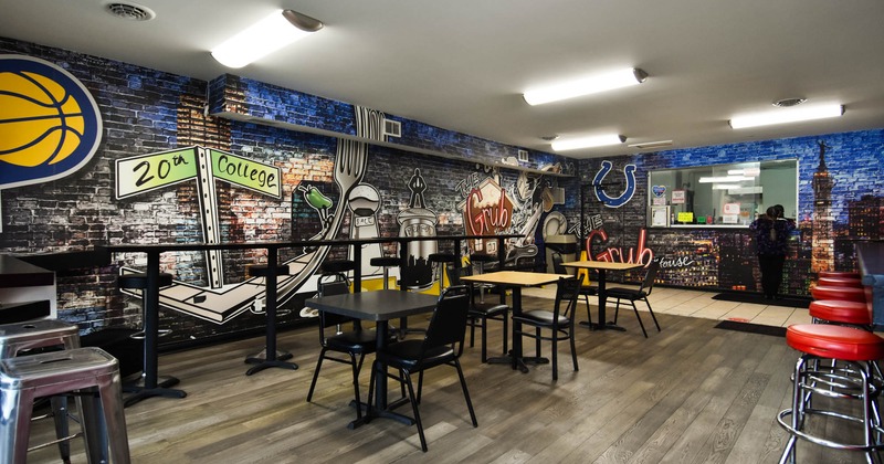 Interior, seating area, tables for four and two, over-the-wall mural, brick wall
