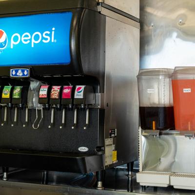 Interior, a soft drink fountain beside juice dispensers.