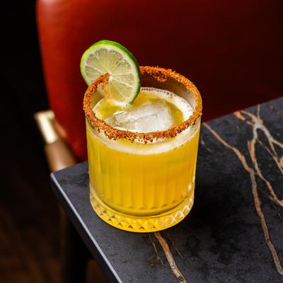 Margarita with the glass rimmed with tajin, and garnished with a lime wheel.