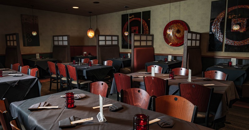 Interior with dark tablecloths, wooden chairs and abstract wall art