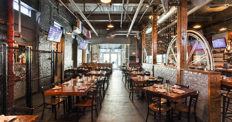 Industrial-style interior with wooden tables, brick walls, exposed beams and pipes