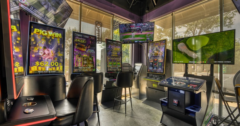 Interior, gaming lounge with slot machines, black chairs and TV's