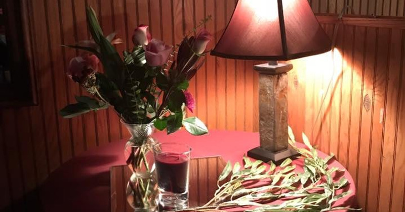 A vase of flowers and a dimly lit lamp on a table
