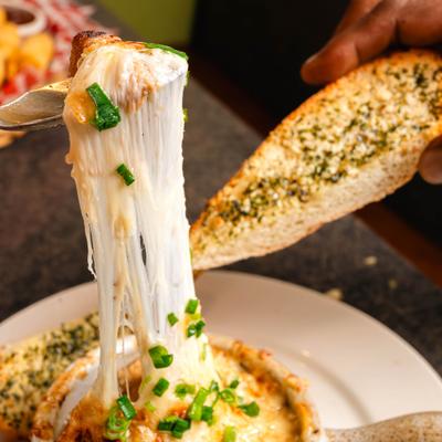 Cheesy Baked French Onion soup served with garlic bread.