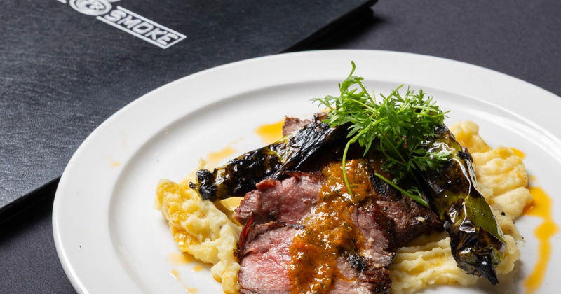 Grilled steak with mashed potatoes and sauce on a white plate