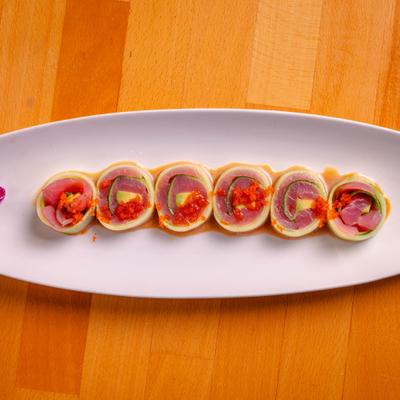 Tuna Naruto sushi roll served on tle oval plate, overhead view.