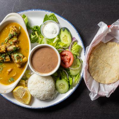 Pork ribs in green salsa, served with salad, rice, beans, and tortillas.