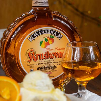 A bottle of Kruskovac drink and a poured glass.