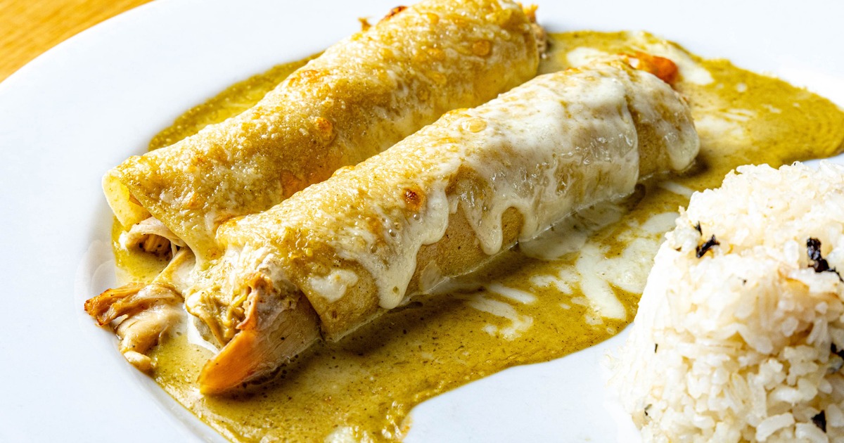 Two chicken enchiladas with green salsa and melted cheese
