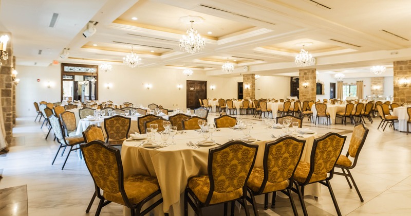 Interior, event area, oval tables for eight, cream cloth, ready for guests, tile flooring