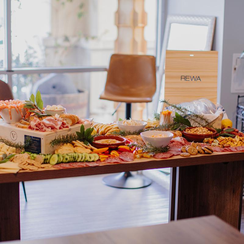 Grazing table with variety of cheeses, meats, fruits, nuts, dips and crackers.