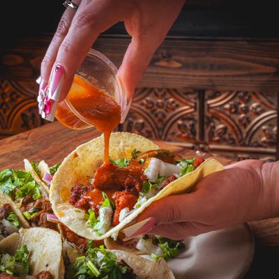 Sauce being poured over the taco.