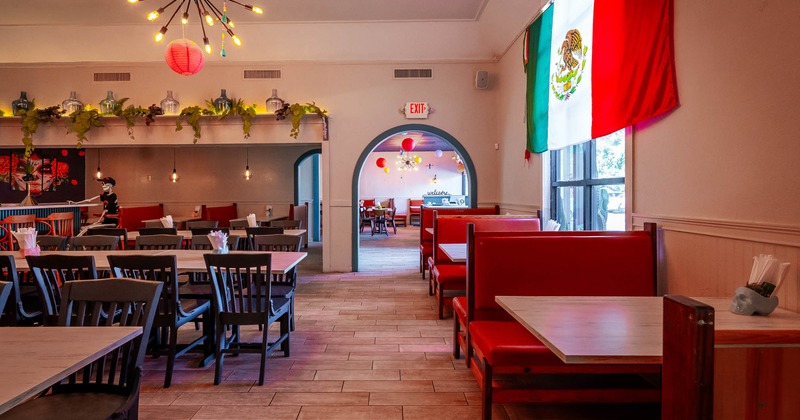 Interior, seating area with booths, tables and chairs, Mexican flag on the wall on the right