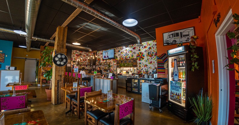 Interior, tables and chairs with bar in the back