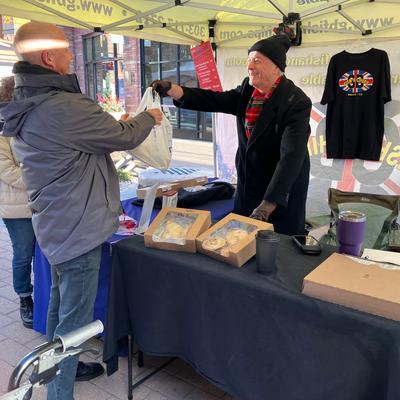 GB Fish and Chips stall, an employee hands out an order to a couple of customers.