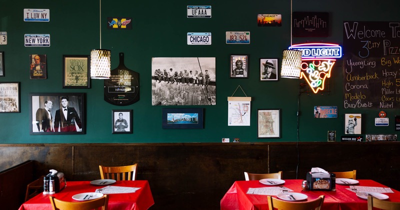 Tables ready for guests next to a decorated wall