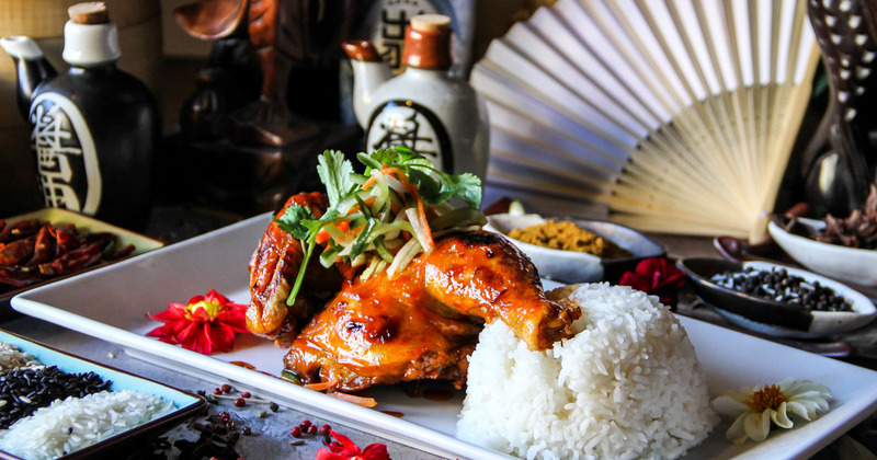 Roast chicken garnished with coriander and carrot, served with rice