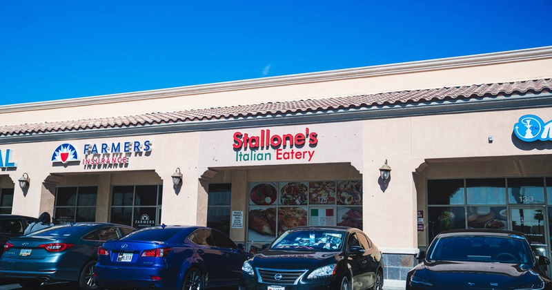 Exterior, entrance to restaurant, sign above, parking lot in front