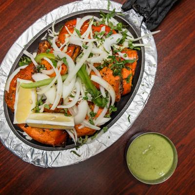 Tandoori chicken with green sauce on the side.