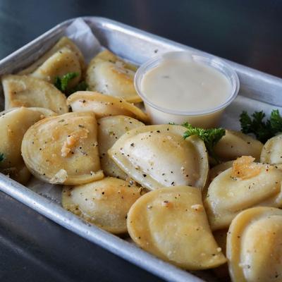 Cheese pierogis served with cheese dip.