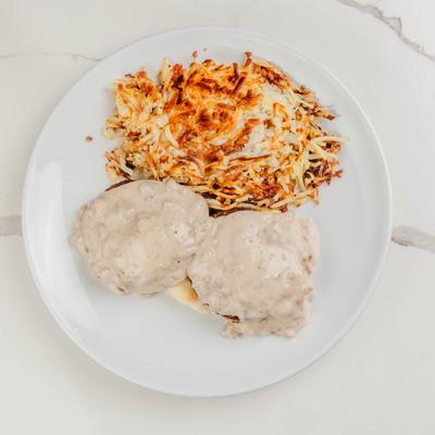 Southern benedict with biscuits and gravy, alongside hush browns.