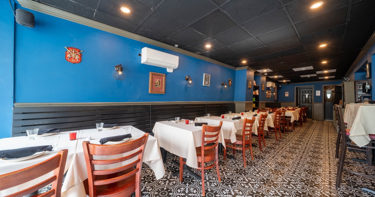 Interior - blue walls, black-white patterned tile floor, wooden chairs, wall decorations