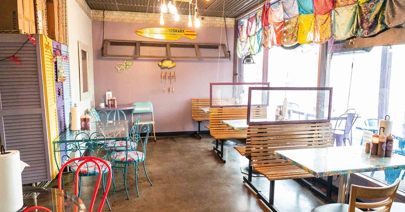 Wide view of the dining room with booths,  tables and chairs