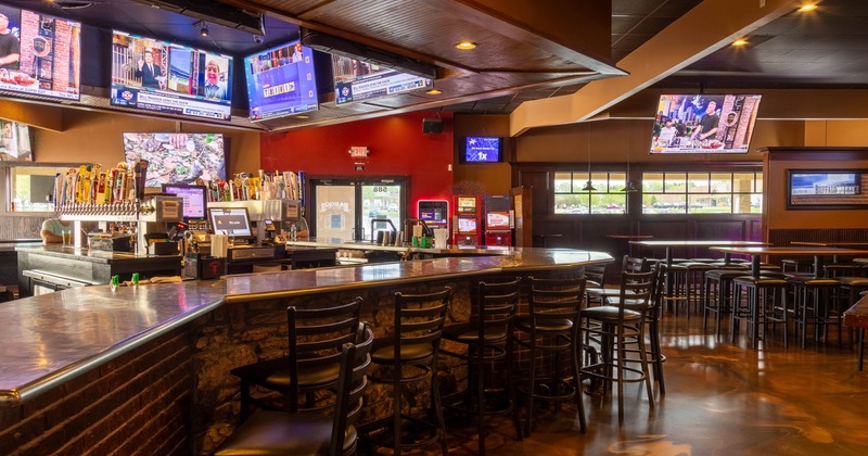 Interior, bar area, bar with stools, beer taps behind the bar, seating area on the right