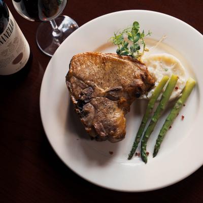 Veal chop served with mashed potatoes and asparagus.