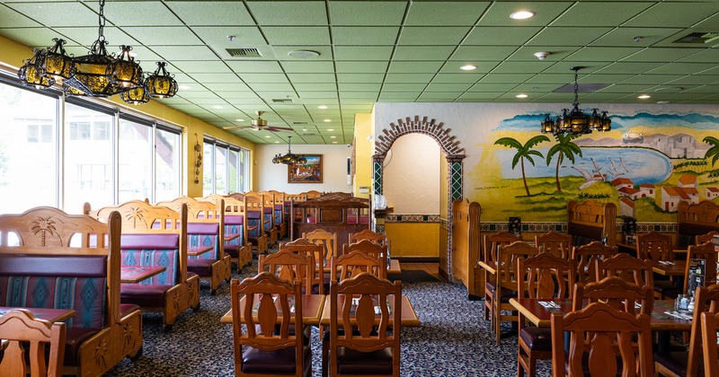 Interior of a cozy Mexican-style restaurant, spacious dining area with wooden tables and chairs